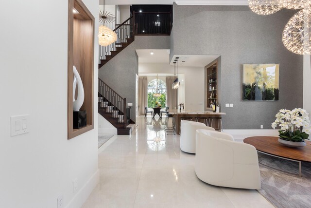 living room with an inviting chandelier, a towering ceiling, and expansive windows