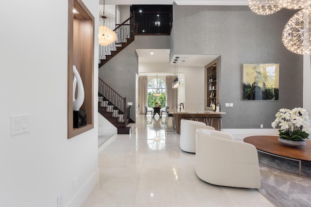 foyer entrance with a towering ceiling, stairway, and a chandelier