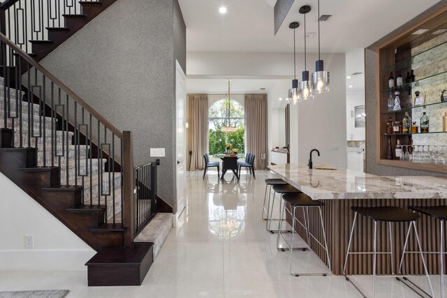 living room with sink, a chandelier, and a high ceiling