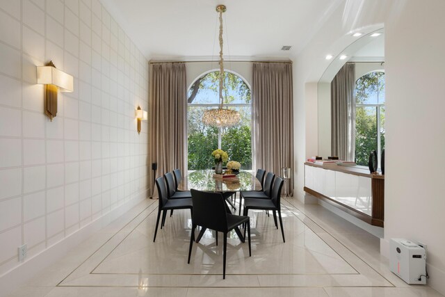 living room with an inviting chandelier, sink, ornamental molding, and a high ceiling