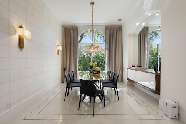 dining area featuring a chandelier, plenty of natural light, and tile walls