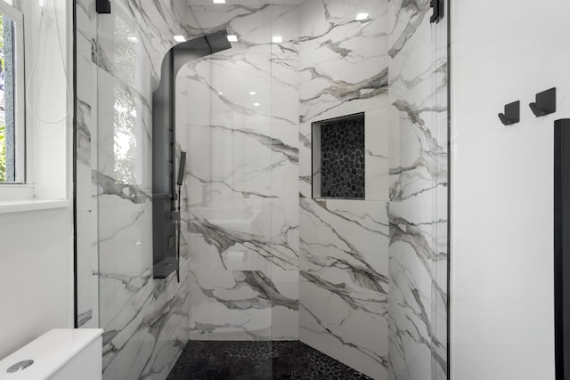 full bath with toilet and a marble finish shower