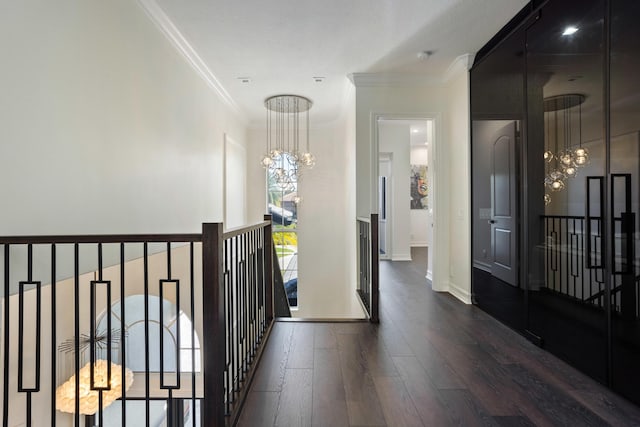 hall with a notable chandelier, ornamental molding, an upstairs landing, wood finished floors, and baseboards