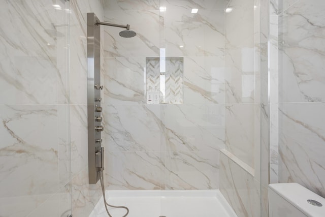 full bath with a marble finish shower and toilet