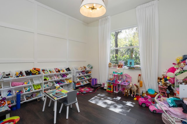 game room featuring a decorative wall and wood finished floors