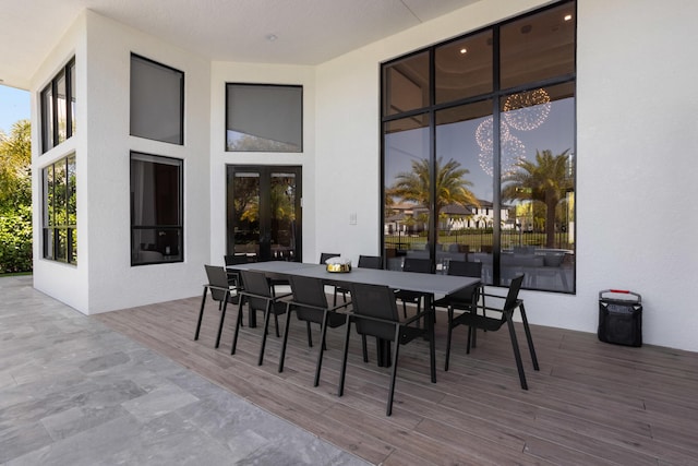 view of patio with a deck, french doors, and outdoor dining space