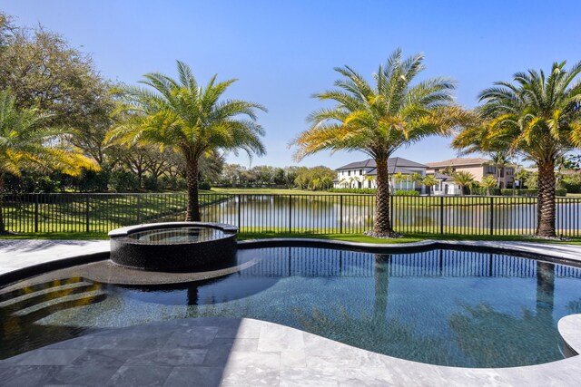 view of swimming pool featuring a water view, an in ground hot tub, and a patio