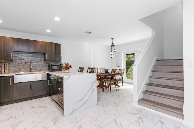 kitchen featuring pendant lighting, kitchen peninsula, sink, tasteful backsplash, and dark brown cabinetry