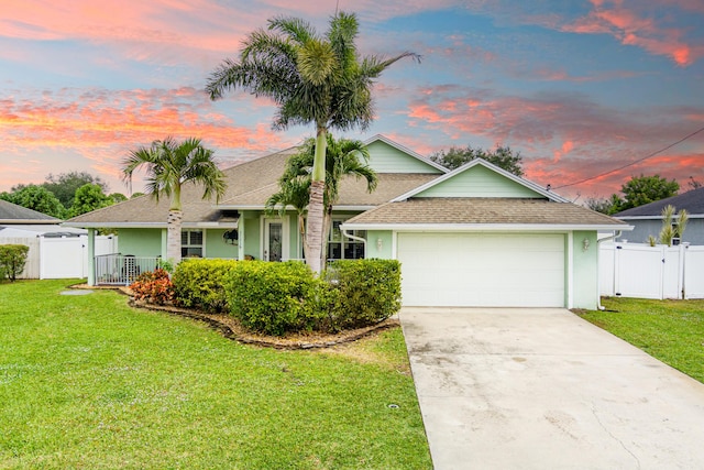 view of front of property with a garage and a lawn