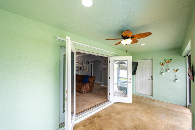 unfurnished sunroom featuring ceiling fan