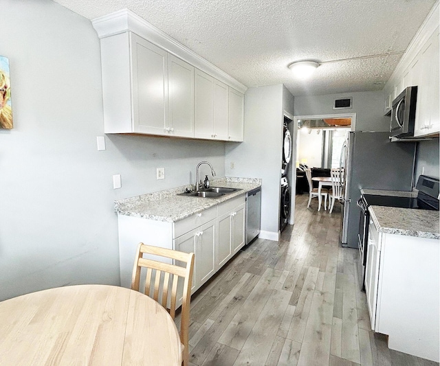 kitchen with light wood-type flooring, stainless steel appliances, sink, and white cabinets