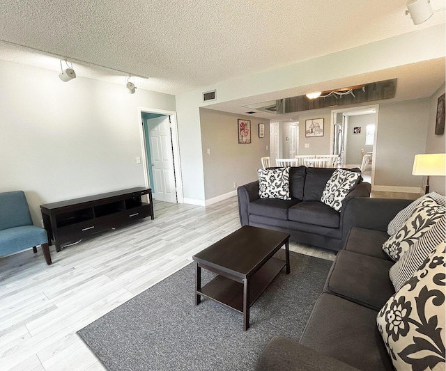 living room with a textured ceiling and hardwood / wood-style flooring