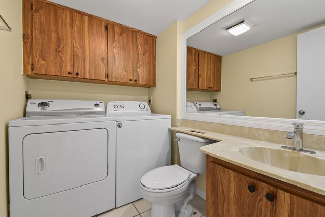 laundry area featuring sink, light tile patterned floors, and washing machine and clothes dryer