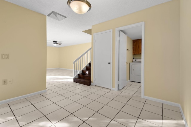 tiled spare room with washer / dryer, a textured ceiling, and ceiling fan