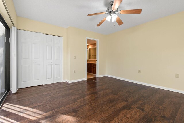 unfurnished bedroom featuring dark hardwood / wood-style floors, ceiling fan, and a closet