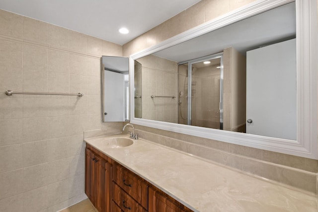 bathroom featuring vanity, tile walls, and a shower