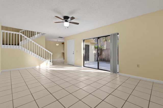 tiled spare room featuring ceiling fan and a textured ceiling