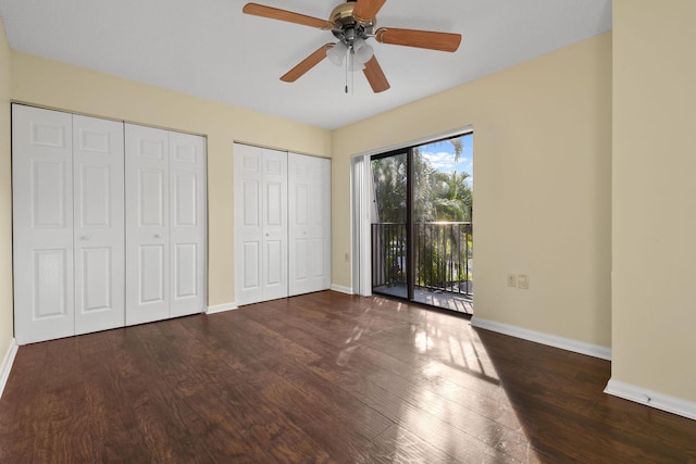 unfurnished bedroom with multiple closets, ceiling fan, dark hardwood / wood-style flooring, and access to outside