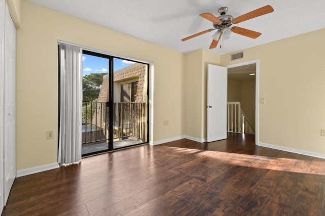 spare room with dark hardwood / wood-style floors and a textured ceiling