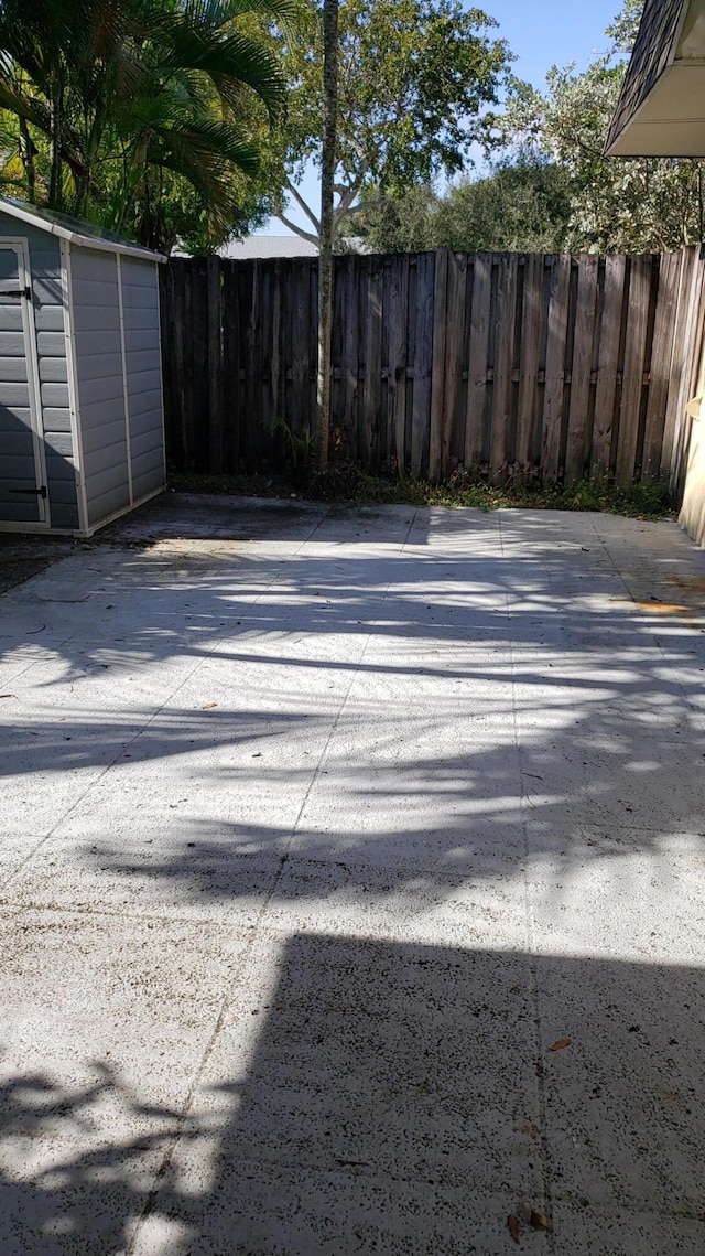 view of yard featuring a shed and a patio