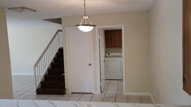 stairway featuring tile patterned flooring and washer / dryer