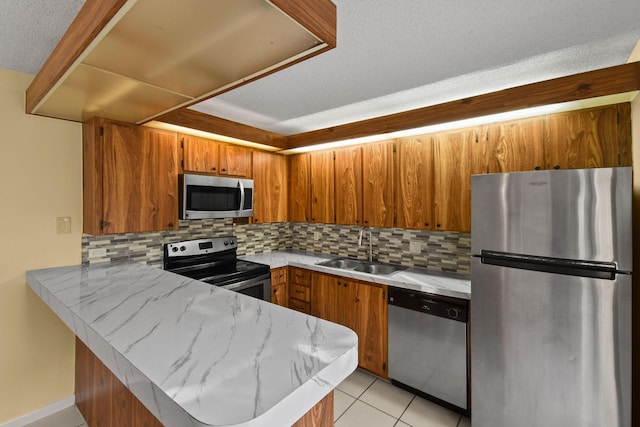 kitchen featuring tasteful backsplash, appliances with stainless steel finishes, sink, and kitchen peninsula