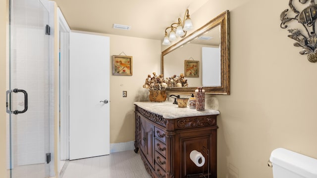 bathroom with vanity, toilet, and a shower with door