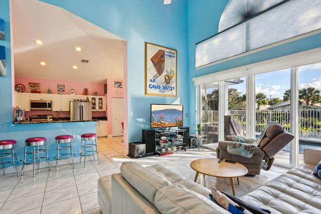 tiled living room featuring a high ceiling