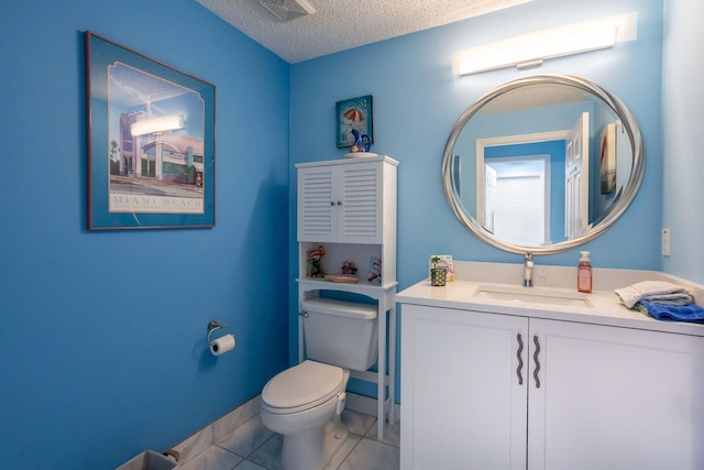 bathroom with vanity, toilet, and a textured ceiling