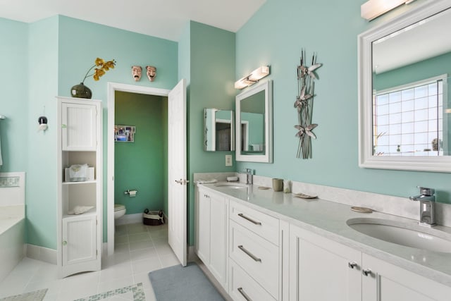 bathroom featuring vanity, tile patterned flooring, a tub, and toilet