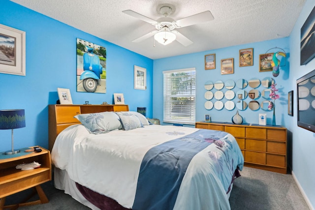 bedroom featuring ceiling fan, dark carpet, and a textured ceiling