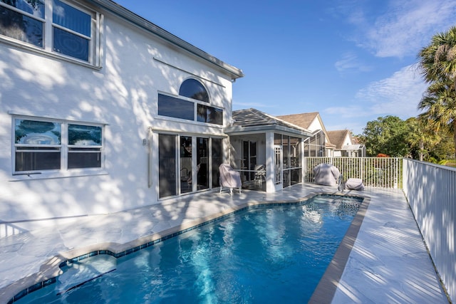 view of swimming pool with a sunroom and a patio area