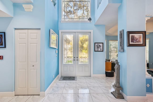 foyer entrance featuring french doors and a towering ceiling