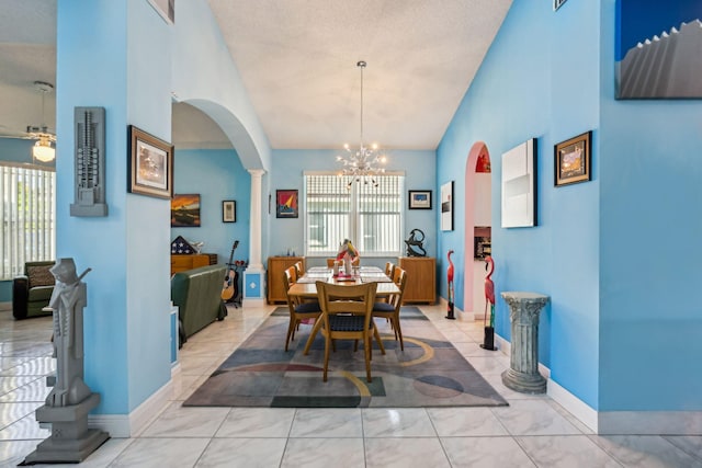 dining space featuring decorative columns, lofted ceiling, a textured ceiling, and an inviting chandelier