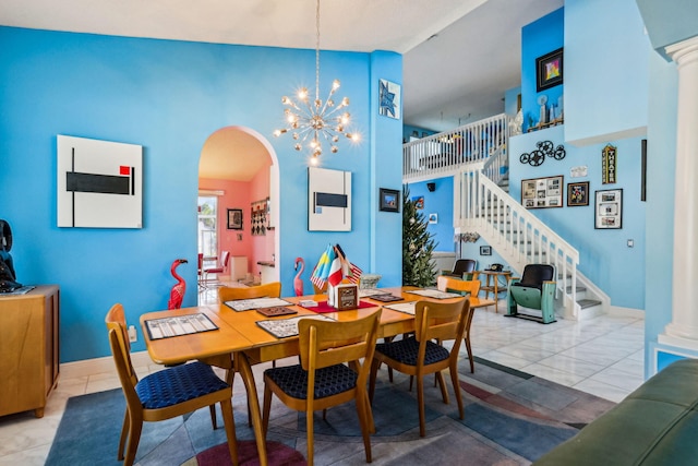 dining area featuring an inviting chandelier, light tile patterned flooring, and high vaulted ceiling