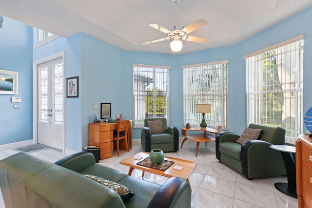 living room featuring light tile patterned floors, plenty of natural light, french doors, and ceiling fan