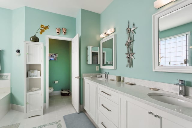 full bath featuring a sink, toilet, double vanity, and tile patterned flooring