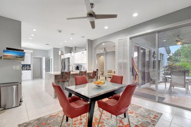 tiled dining space with sink and ceiling fan