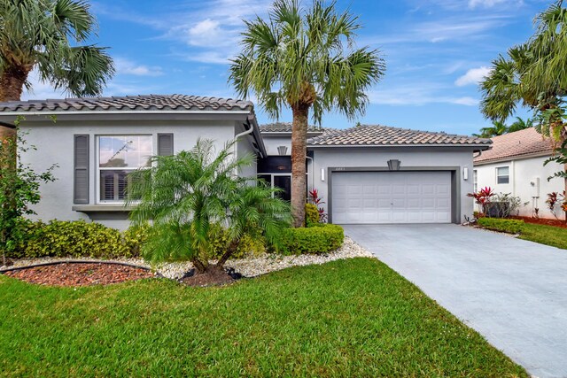 mediterranean / spanish home with a front yard and a garage