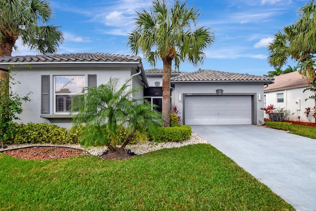 mediterranean / spanish-style home featuring a garage and a front lawn