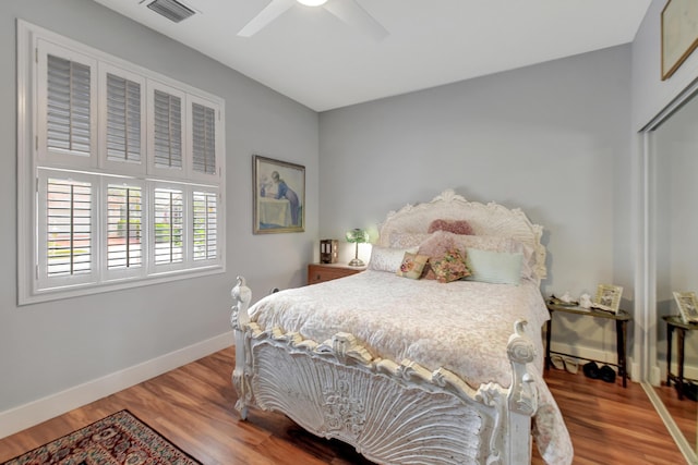 bedroom featuring hardwood / wood-style flooring, ceiling fan, and a closet