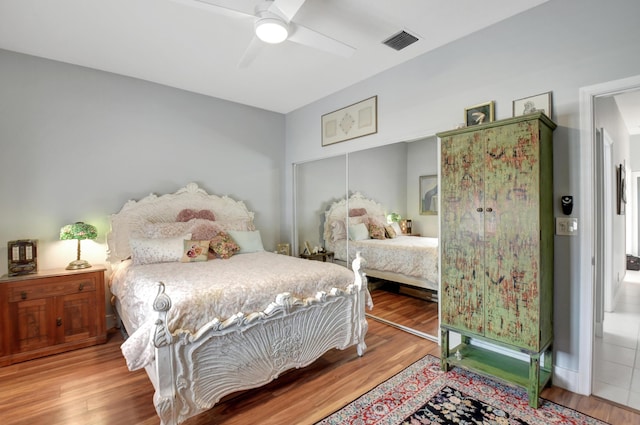 bedroom featuring hardwood / wood-style flooring, ceiling fan, and a closet