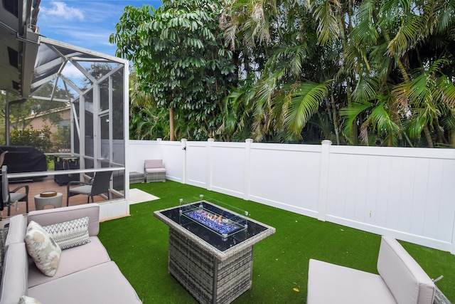 view of yard featuring a lanai, a patio, and an outdoor fire pit