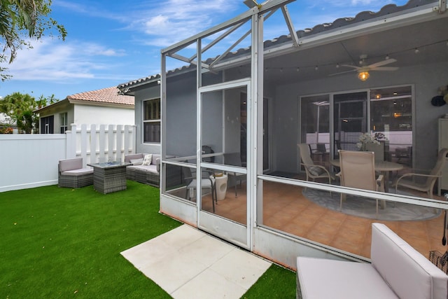 exterior space with ceiling fan, a sunroom, an outdoor living space, and a patio area