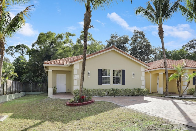 mediterranean / spanish home featuring a front lawn