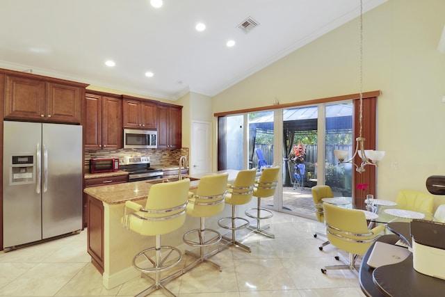 kitchen featuring light stone countertops, tasteful backsplash, crown molding, a breakfast bar, and appliances with stainless steel finishes