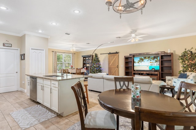 dining area featuring a barn door, sink, light tile patterned floors, and ornamental molding