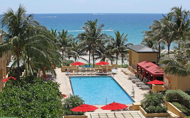 view of swimming pool featuring a water view and a patio area