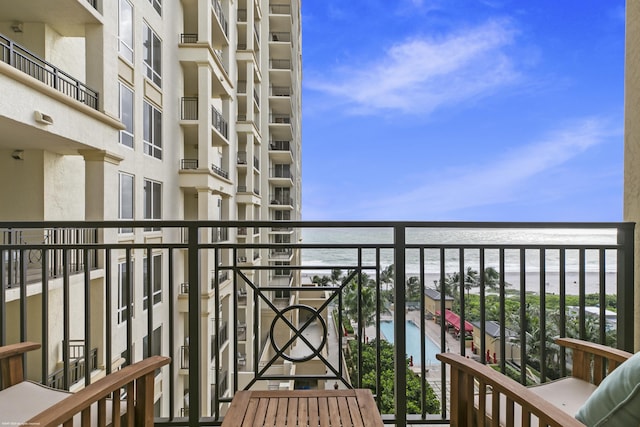 balcony with a water view and a beach view