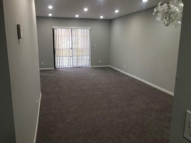 unfurnished room featuring dark carpet